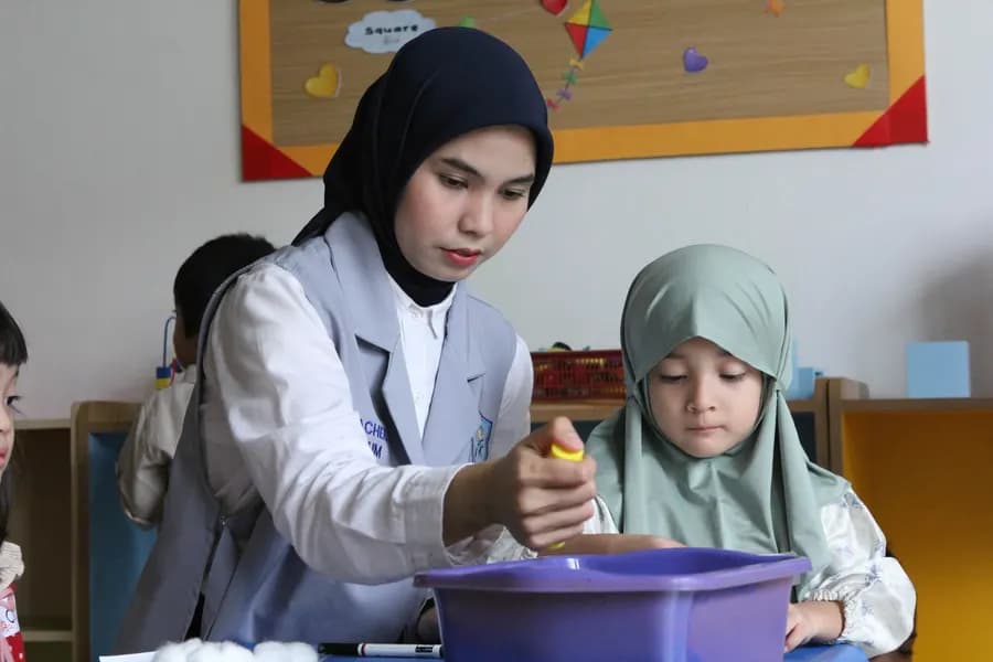 Guru mendampingi murid berkegiatan di kelas